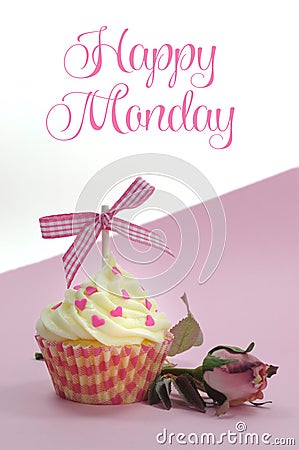 Pretty pink cupcake with pale pink silk rose bud on pink background with Happy Monday sample text Stock Photo