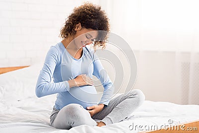 Pretty pregnant woman caressing her belly, talking to her baby Stock Photo