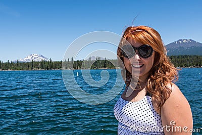 Pretty red hair female adult poses by Lava Lake along the Cascade Lakes Scenic Byway Stock Photo