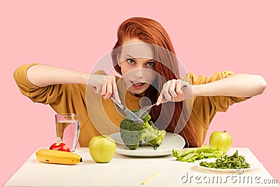 Pretty redhead caucasian woman sitting at table with healthy food and broccoli Stock Photo