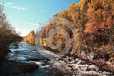 Pretty river in fall with a waterfall in Quebec Stock Photo