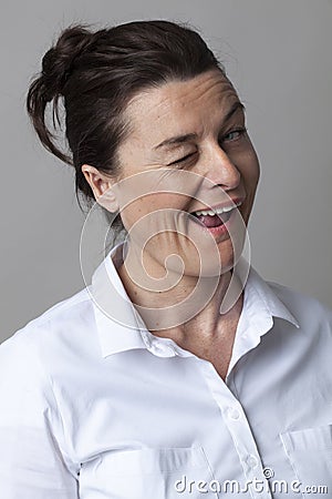 Pretty 40s woman winking for fun with serenity Stock Photo