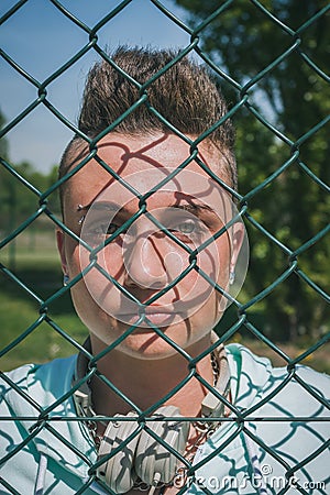 Pretty short hair girl behind a metallic net Stock Photo