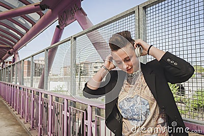 Pretty short hair girl listening to music on a bridge Stock Photo