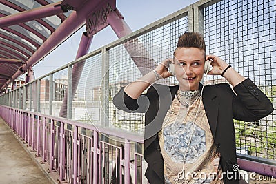 Pretty short hair girl listening to music on a bridge Stock Photo