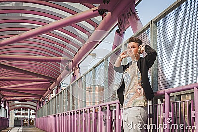 Pretty short hair girl listening to music on a bridge Stock Photo