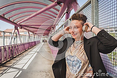 Pretty short hair girl listening to music on a bridge Stock Photo