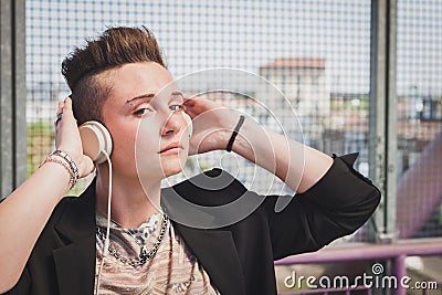 Pretty short hair girl listening to music on a bridge Stock Photo