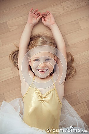 Pretty smiling ballet chilg girl in white tutu on floor Stock Photo