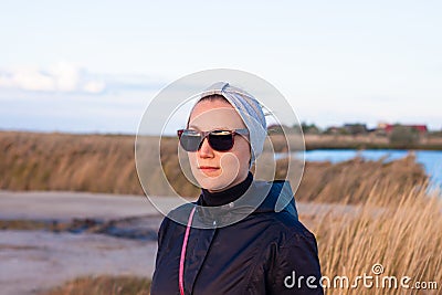 Pretty smiling confident woman in gray headband walking on sea background lifestyle real life travel. Millennial hipster Stock Photo