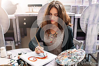 Pretty smiling woman drawing at studio Stock Photo