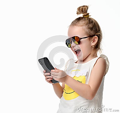 Young girl reading texting sms on the cellphone mobile with touch screen in sunglasses Stock Photo