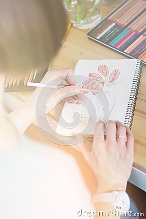 Pretty smiling young woman drawing a picture with poster paint, light toning Stock Photo