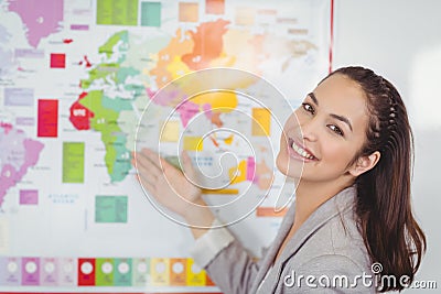 Pretty teacher showing world map in a classroom Stock Photo