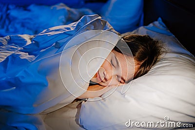 The pretty teen girl naps in bedroom, sees a pleasant sleep and smiles Stock Photo