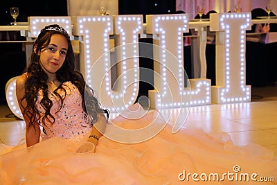 Pretty teen quinceanera birthday girl celebrating in princess dress pink party, special celebration of girl becoming woman. Stock Photo