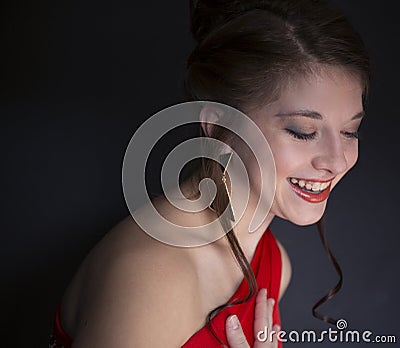 Pretty teenage girl laughing and wearing red prom dress Stock Photo