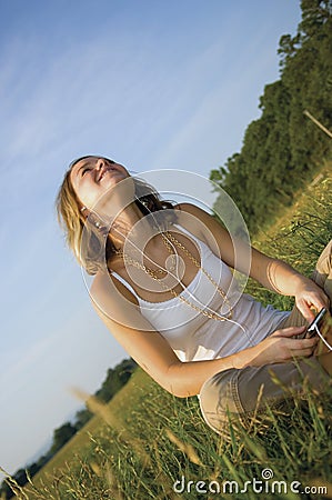 Pretty Teenage Girl listening to portable music player Stock Photo