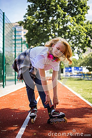 Pretty Teenage Girl Wearing Roller Skaters On The Road In Summe Park. Stock Photo