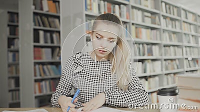 Pretty teenage girl writes a letter in notebook at library closeup Stock Photo