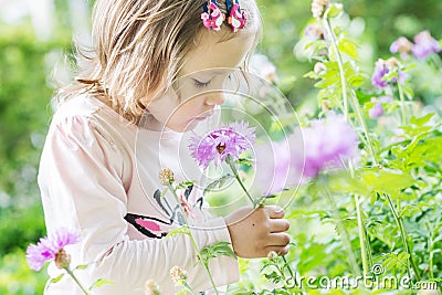 Pretty Toddler girl smelling a flower Stock Photo