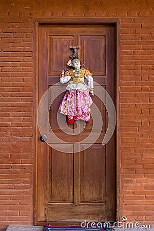 Pretty traditional style Burmese string puppet decoration on copper colored door Stock Photo