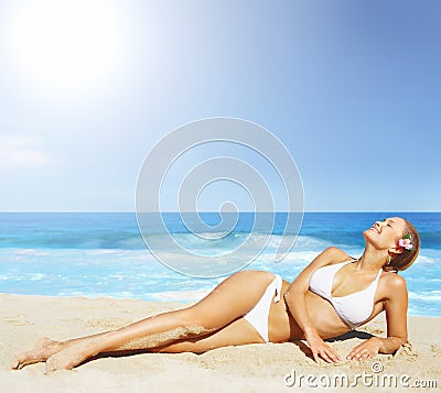 A pretty woman in bikini sunbathing at the beach Stock Photo