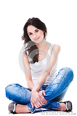 Pretty woman in blue jeans sitting on white floor Stock Photo