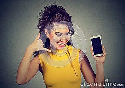 Pretty woman holding mobile phone showing call me hand gesture Stock Photo