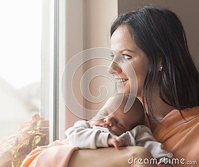 Pretty woman holding a newborn baby in her arms Stock Photo