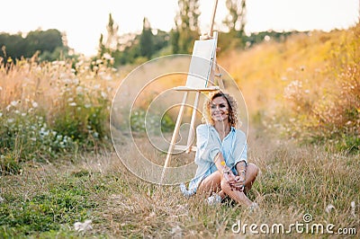 Pretty woman is painting. Open air session. Cute woman draws a picture at sunset. girl artist. Stock Photo