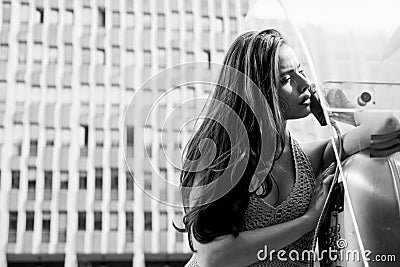 Pretty woman with payphone. Oldfashion town. Vintage concept. Communication. Old styled city. Stock Photo