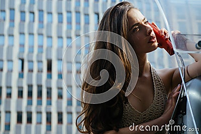 Pretty woman with payphone. Oldfashion town. Vintage concept. Communication. Oldstyled city. Stock Photo