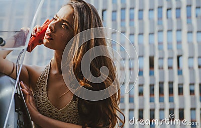 Pretty woman with payphone. Oldfashion town. Vintage concept. Communication. Oldstyled city. Stock Photo