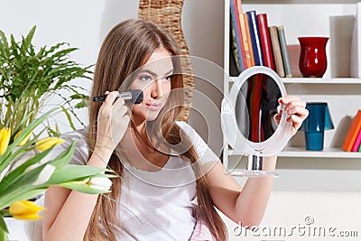 Pretty woman putting makeup on Stock Photo