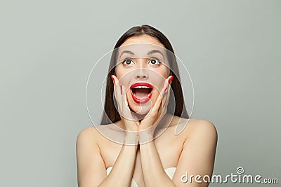 Pretty woman with red manicured nails on white. Surprised female model portrait Stock Photo