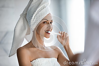 Pretty woman reflected in mirror brushing teeth feels satisfied Stock Photo
