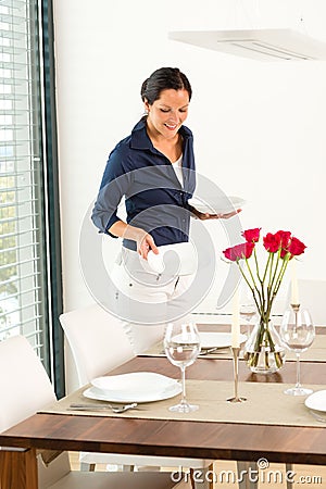 Pretty woman setting table dining room preparing Stock Photo