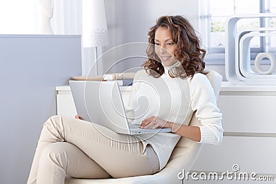 Pretty woman using laptop computer at home Stock Photo