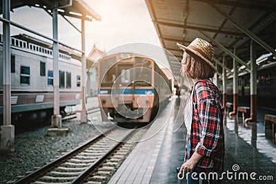 Pretty woman waiting the train at train station for travel in summer. Travel concept. Stock Photo