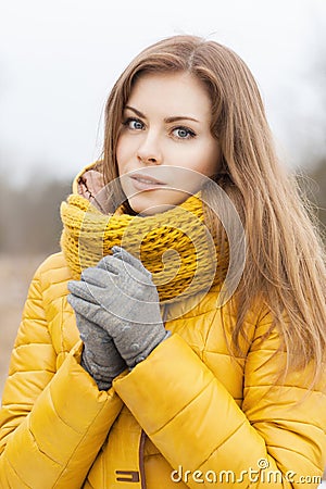 Pretty woman in a yellow knit scarf. Warm hands. Stock Photo