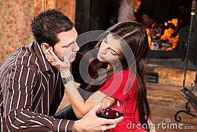 Woman caress her man near fireplace Stock Photo