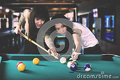 Pretty women playing billiards Stock Photo