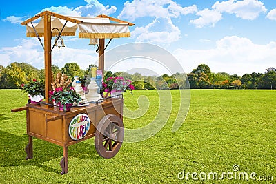 Pretty wooden portable traditional italian picturesque ice cream cart with umbrella in a public park Stock Photo