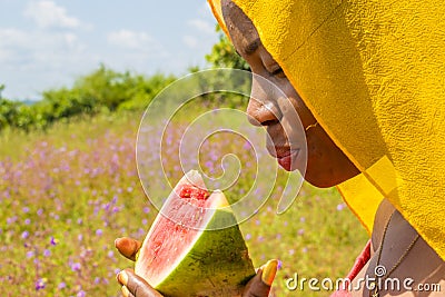 pretty young african woman eating watermelon outside Stock Photo