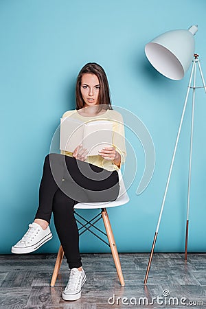Pretty young atractive woman looking at camera and holding book Stock Photo