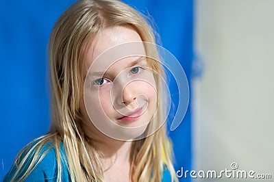 Pretty young blonde girl with blue eyes and an enigmatic smile Stock Photo