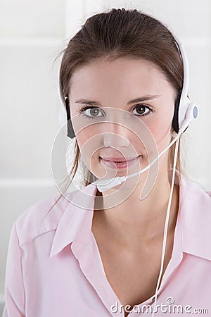 Pretty young business woman in rose blouse with headset. Stock Photo