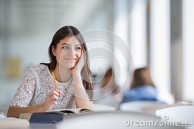 Pretty, young college student looking for a book in the library Stock Photo