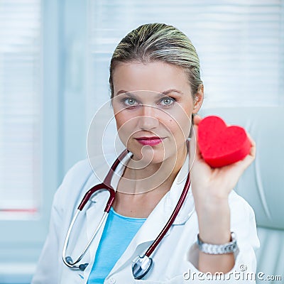 Pretty Young Female Doctor Is Showing a Red Heart Model in Ambulance Stock Photo